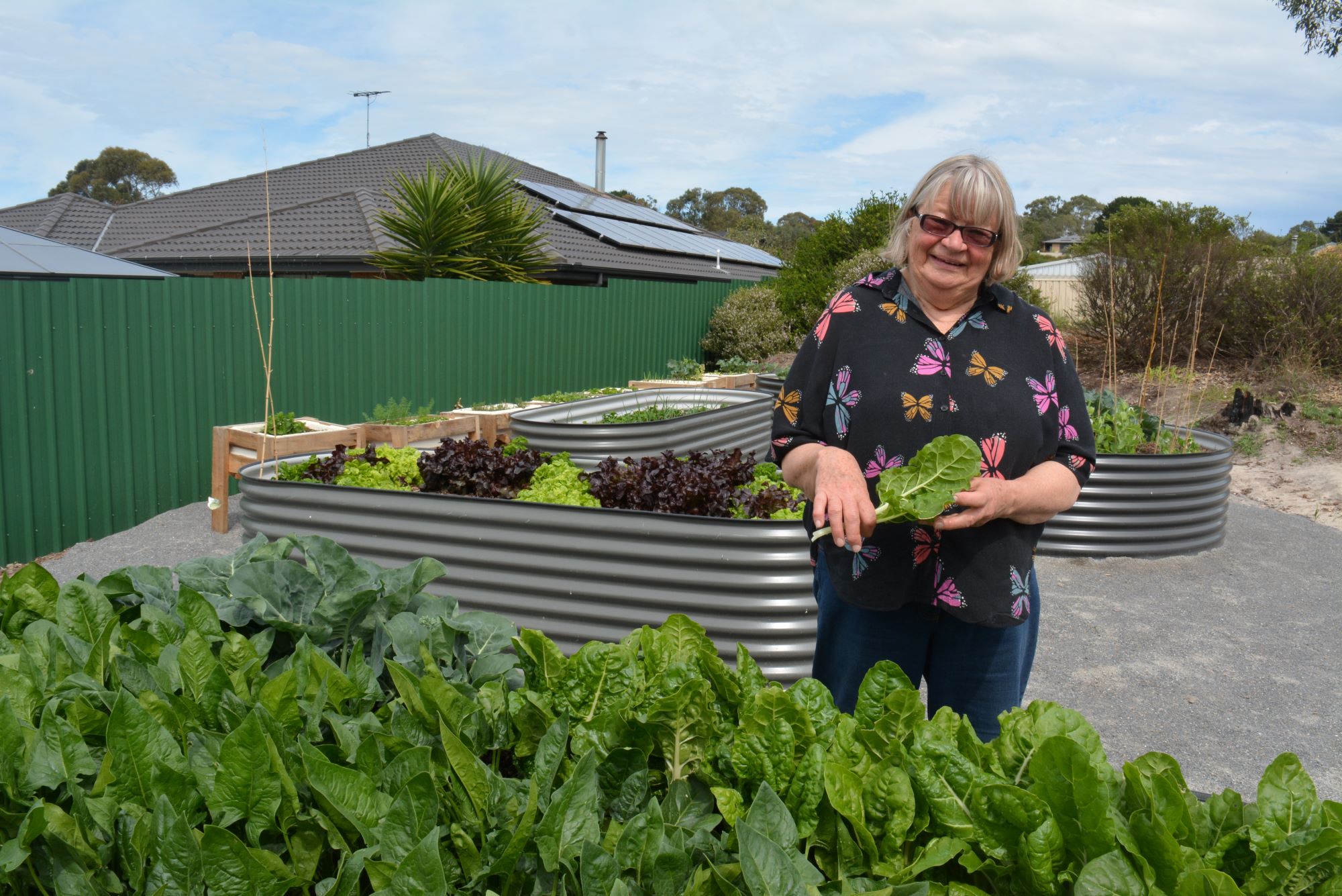 Melita Hicks tends to spinach in the community garden