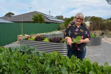 Melita Hicks tends to spinach in the community garden