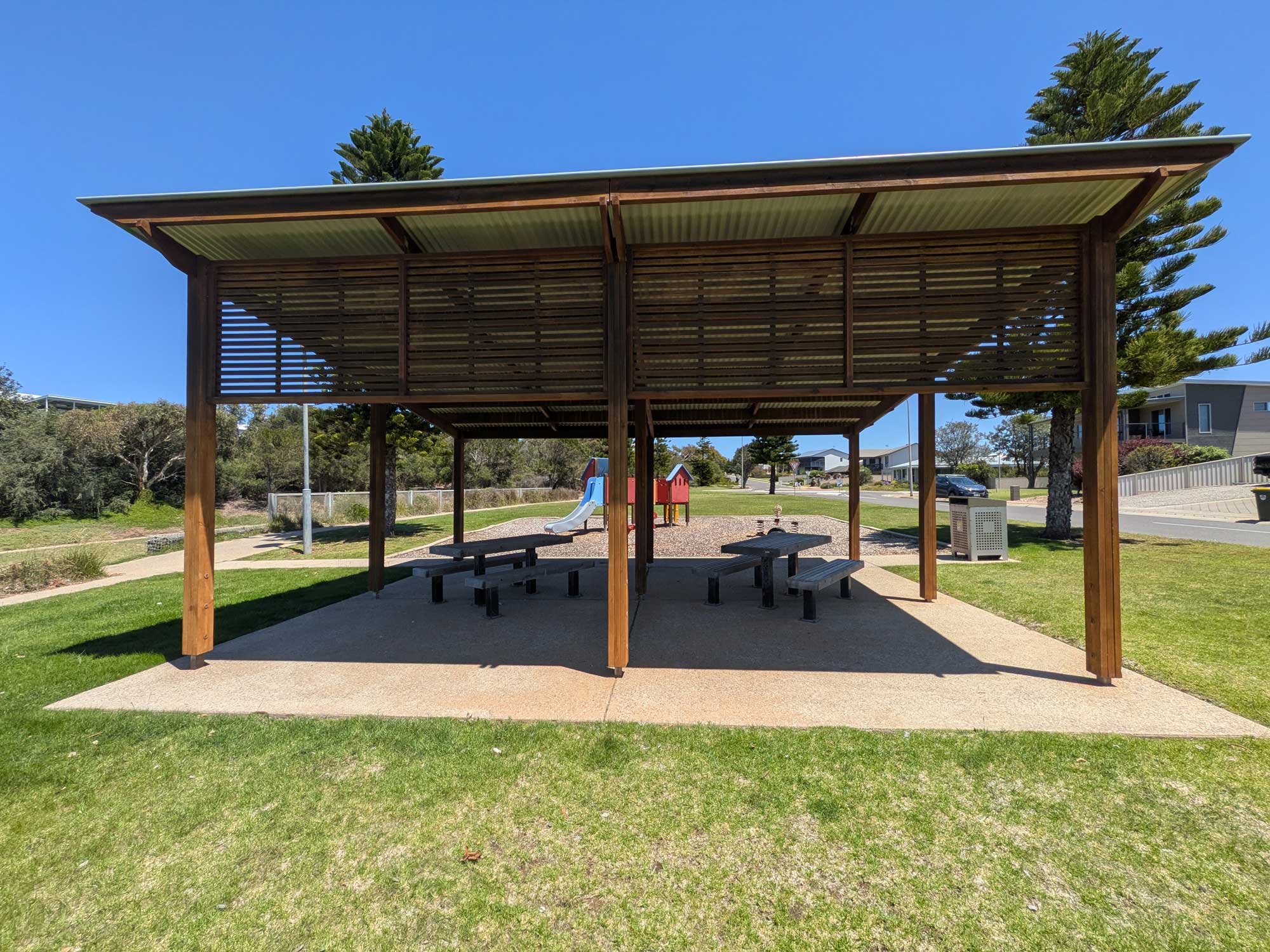 Middleton Shores shelter with picnic seating with playground in background
