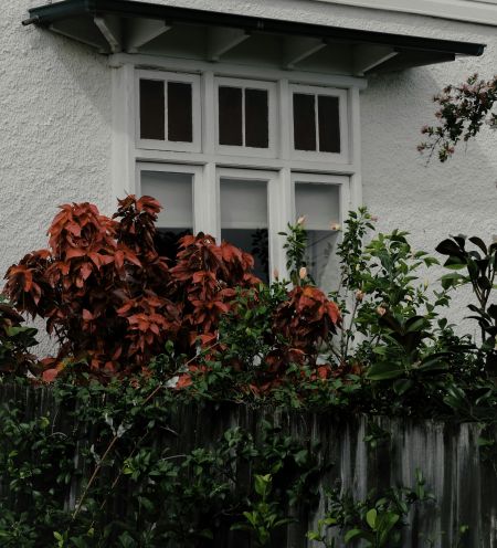 White house with windows and garden in the front 