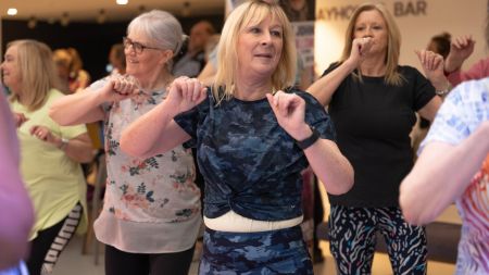 Group of three older women exercising looking happy  